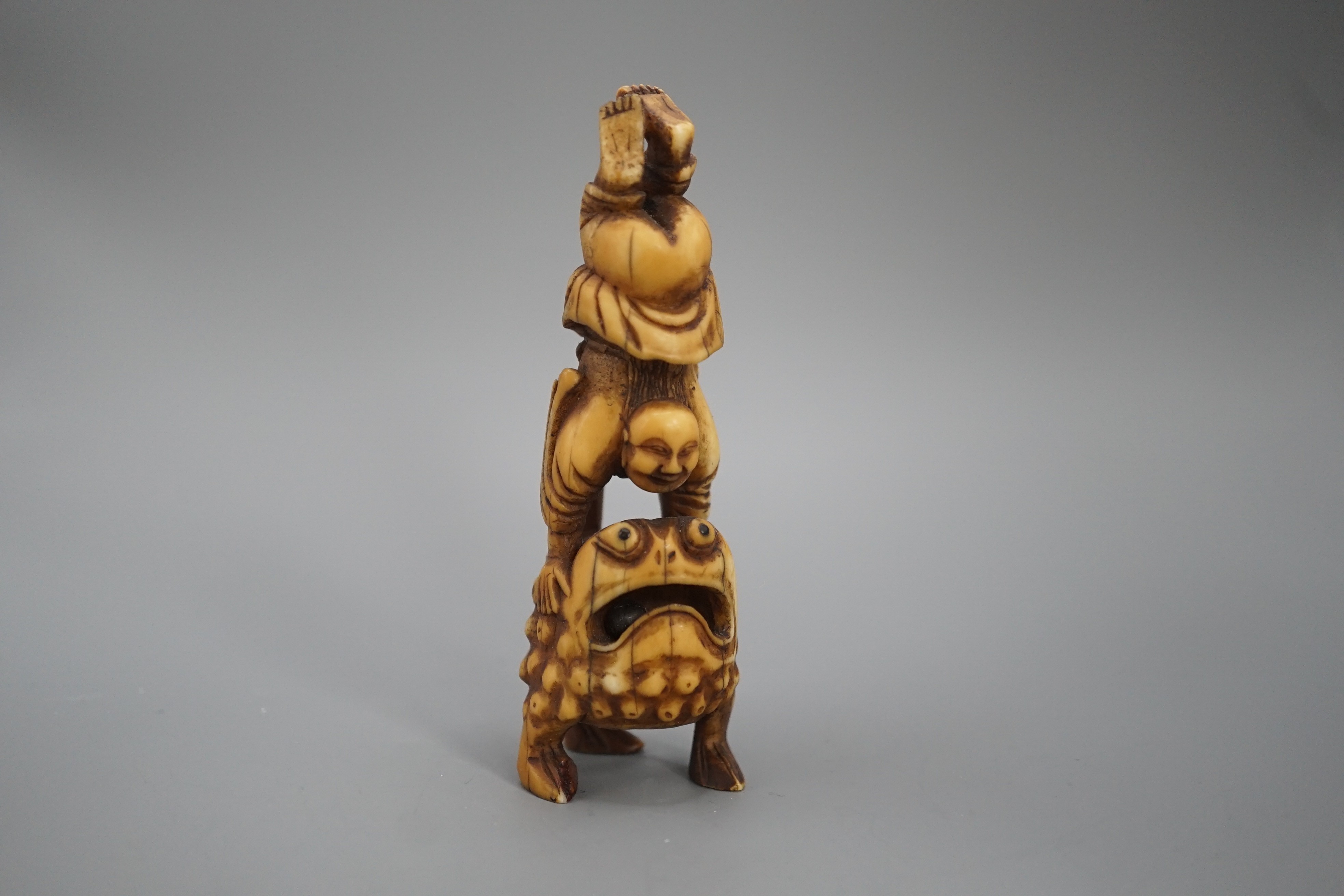 A 19th century Chinese or Japanese carved walrus ivory figure of Liu Hai balancing on his three legged toad, 9cm